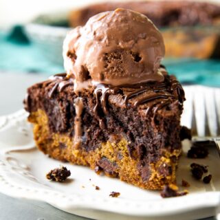 a slice of brookie pie with a scoop of chocolate ice cream on top