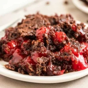plate of moist chocolate cherry dump cake with vibrant red cherries inside