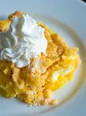 Plate of lemon cream cheese dump cake with cool whip on top