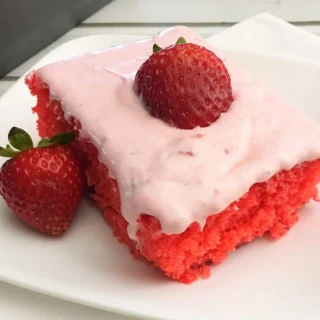 strawberry jello poke cake with strawberries on top