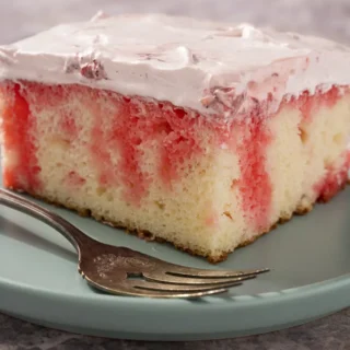 strawberry jello poke cake with pink icing on top