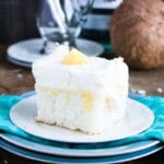 A slice of pina colada cake with a blue napkin.