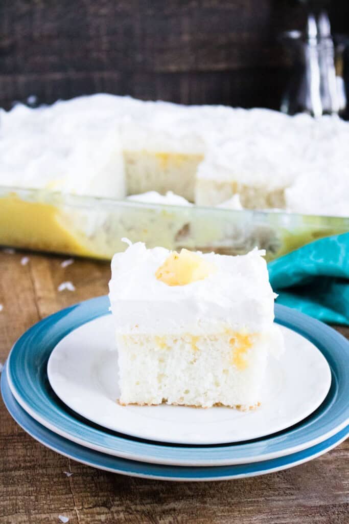 A side view of the pina colada cake on a blue plate.