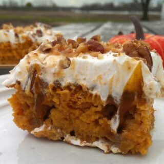 pumpkin poke cake with white frosting, caramel and nuts on top
