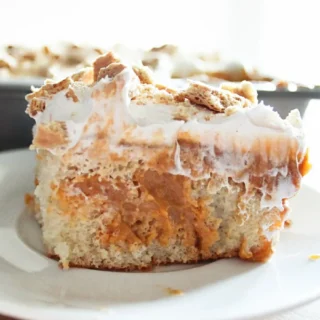 pumpkin pie poke cake topped with fluffy white frosting