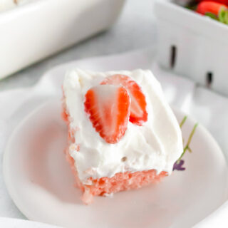 lemon strawberry poke cake with fresh strawberry slices on top