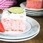 A slice of the strawberry margarita cake with a slice of lime on top.