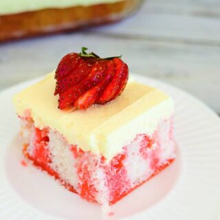 Strawberry vanilla pudding poke cake with fresh strawberries on top