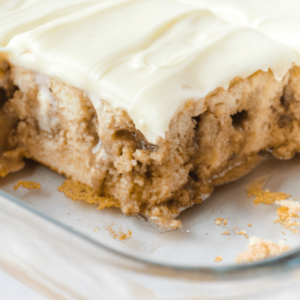 cinnamon roll poke cake with white frosting on top