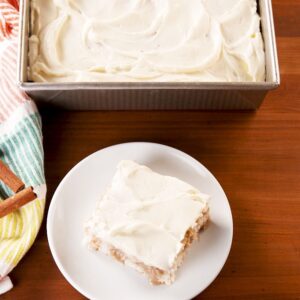 cinnamon roll poke cake with white frosting on top