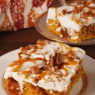pumpkin poke cake with frosting, nuts and caramel drizzle on top