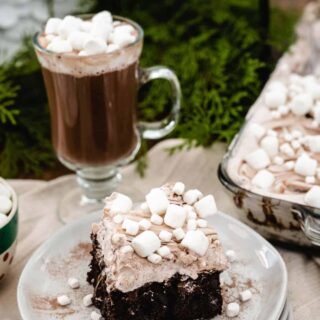 hot chocolate poke cake with tiny marshmallows on top