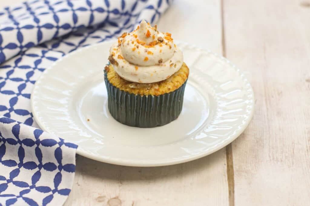 A white dish with the dessert on it and a blue and white check napkin.