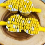 Four cupcakes on a platter with corn holders.