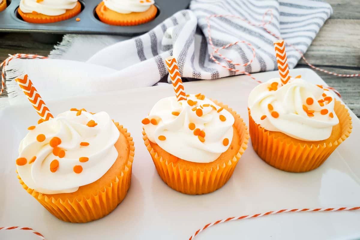 A tray of creamsicle orange cupcakes.