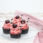 4 black cherry cupcakes on a plate.