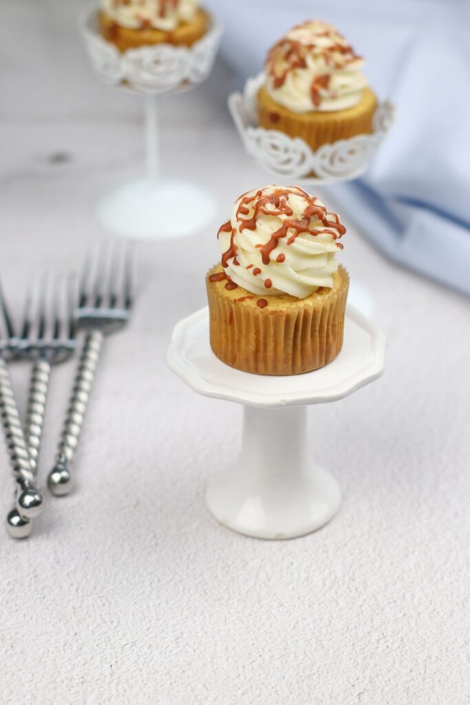 Cinnamon Cupcakes on a cupcake stand with more cupcakes and forks in the background.
