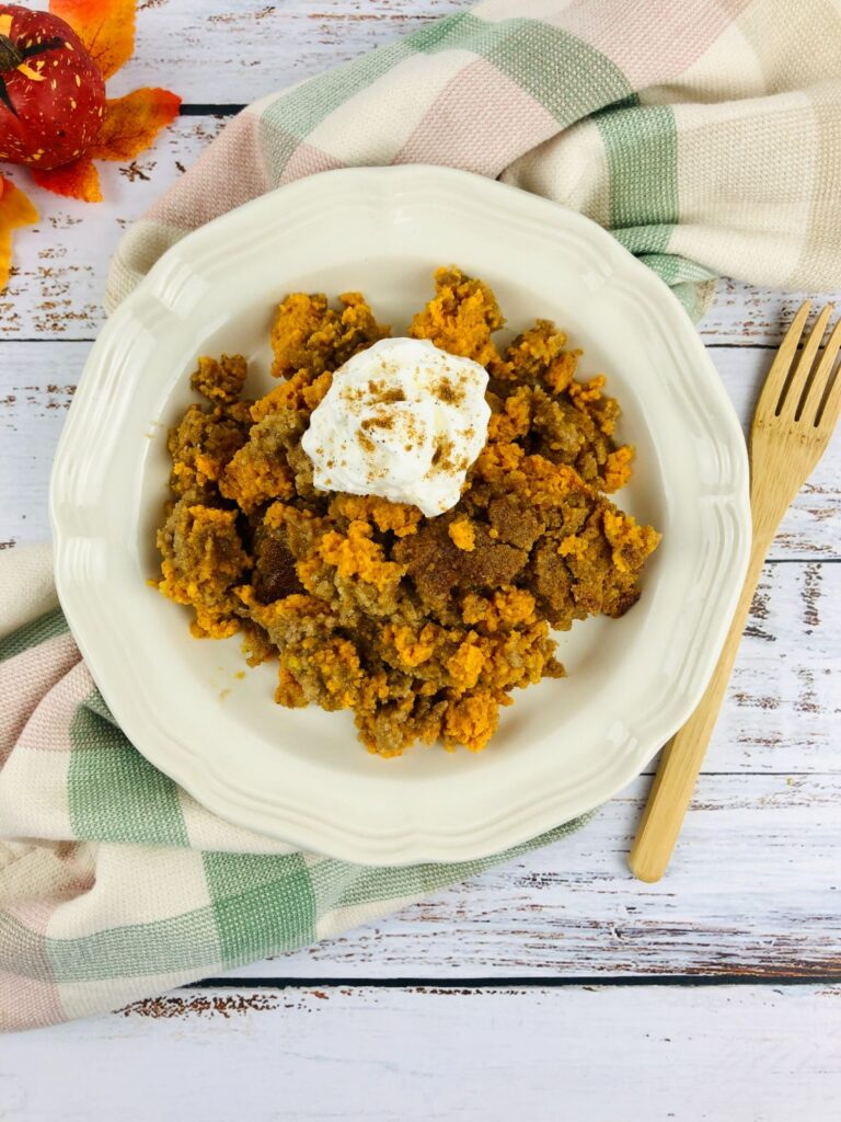 easy Pumpkin Dump Cake on a plate and topped with whipped cream. 