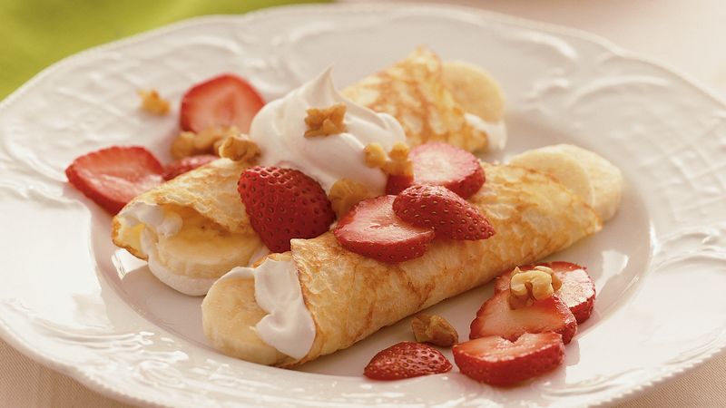 Crepes with whipped cream, strawberries, and walnuts
