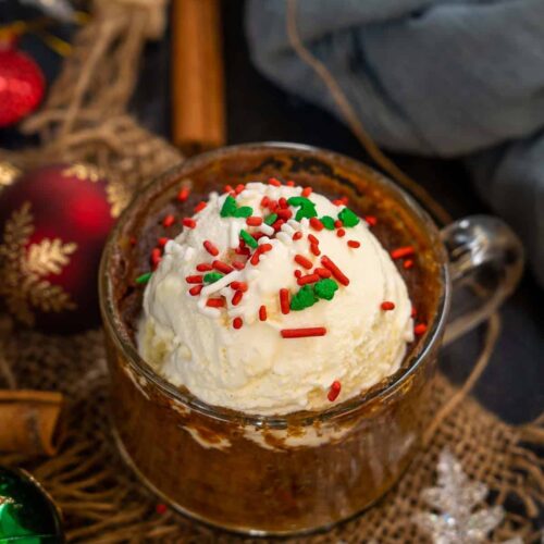 Gingerbread mug cake with ice cream and red and green sprinkles