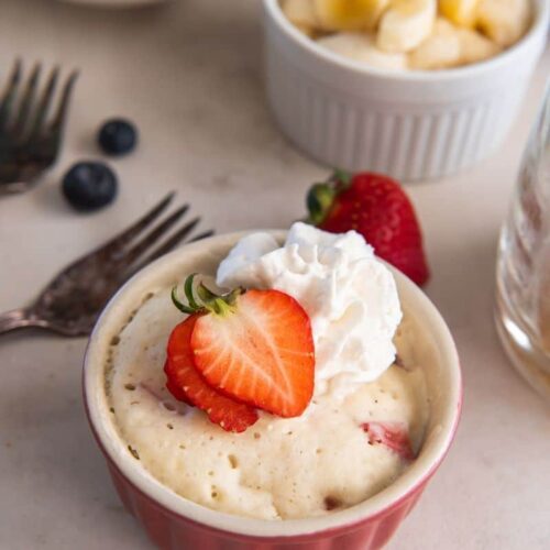 Pancake in a mug with fresh strawberries and whipped cream