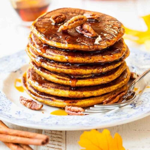 Fluffy pumpkin pancakes with syrup and walnuts