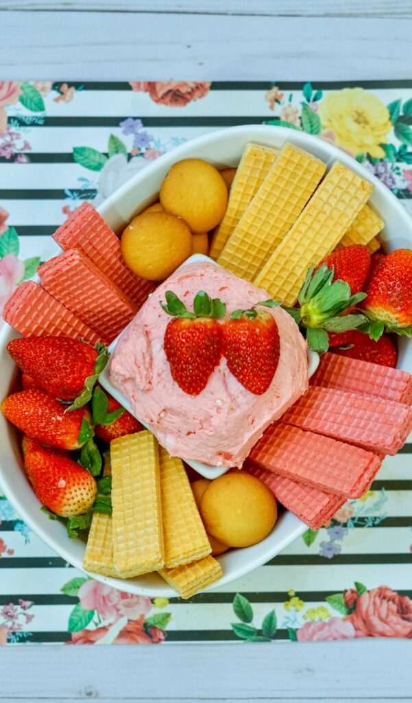 Strawberry Cake Batter Dip on a plate surrounded with fresh strawberries, wafers and cookies.