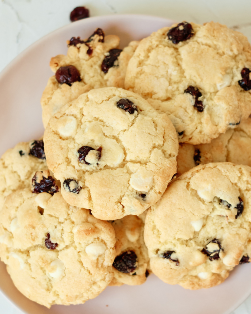 closeup of white chocolate chip cranberry cookies on a plate.