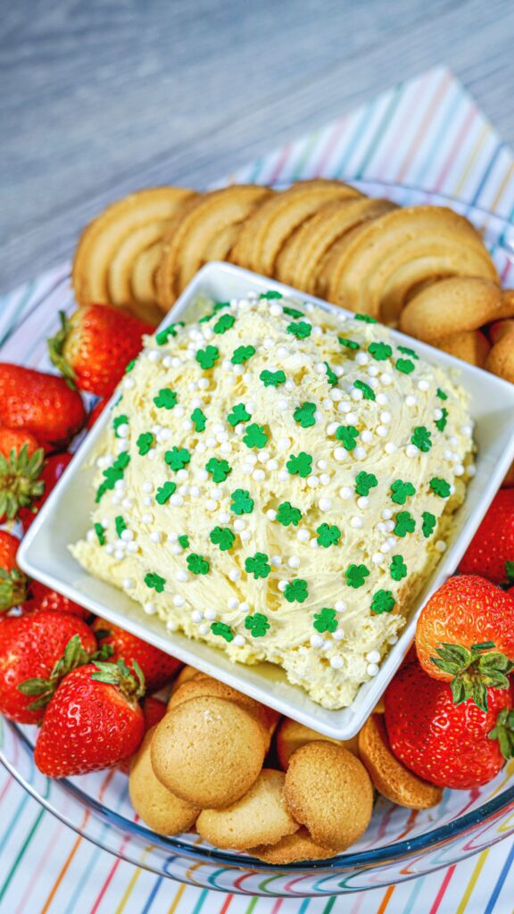 Shamrock Dunkaroo Dip in a bowl surrounded with strawberries and cookies. 