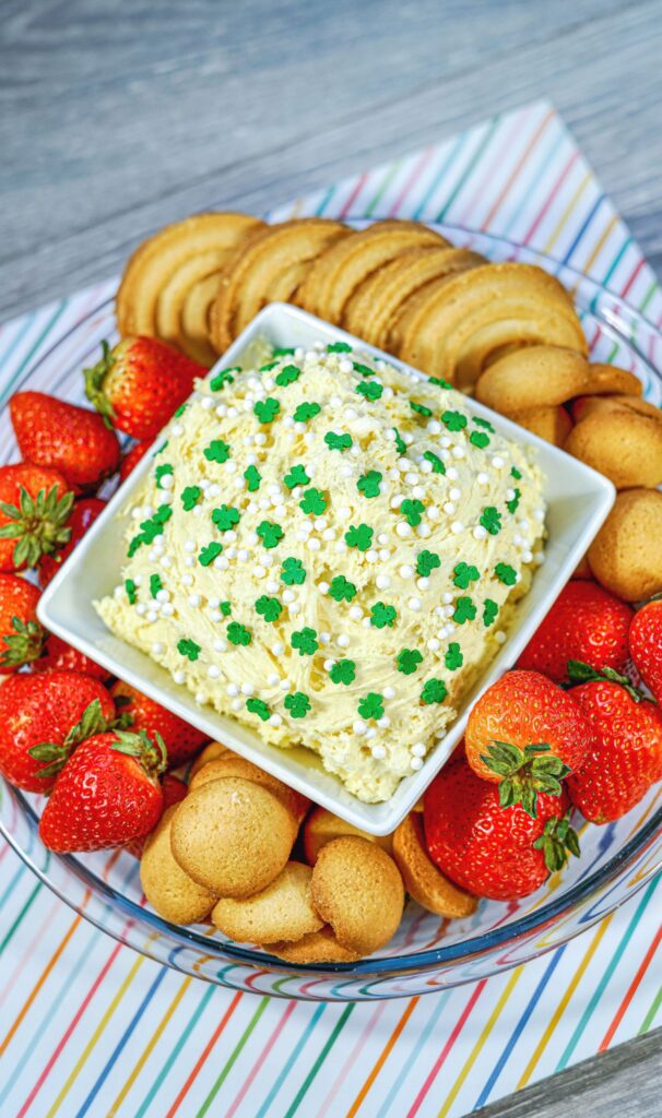 Shamrock Dunkaroo Dip in a bowl surrounded with strawberries and cookies. 