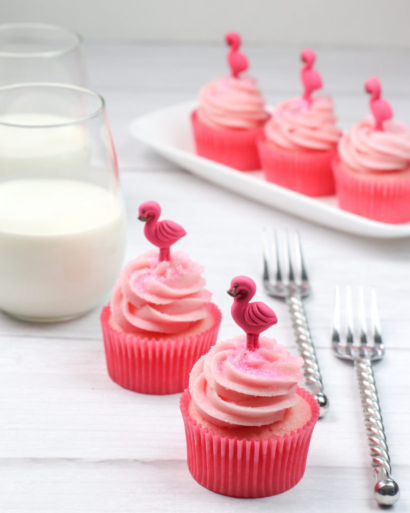 Strawberry and Cream Cupcakes with a glass of milk and fork on the side.