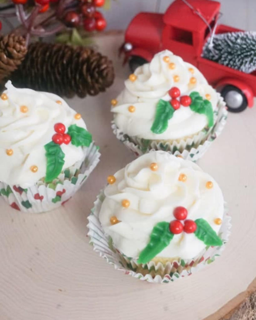 Christmas Holly Cupcakes next to a toy red truck and pinecones.