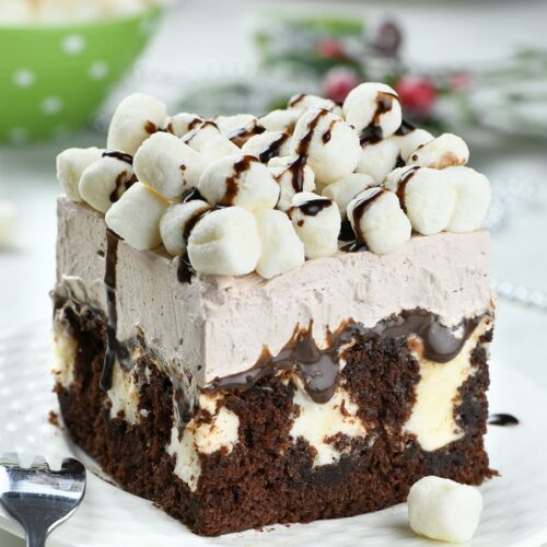 Image of poke cake topped with marshmallows and chocolate drizzle