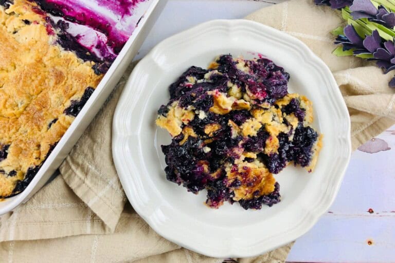 A white plate with blueberry cobbler with cake mix.