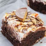 A peanut butter cup on top of the chocolate cake.