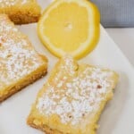 A cake mix lemon bar with a slice of lemon on the side.