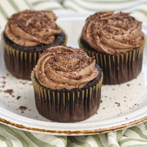 Three cocoa pebbles cupcakes on a plate.