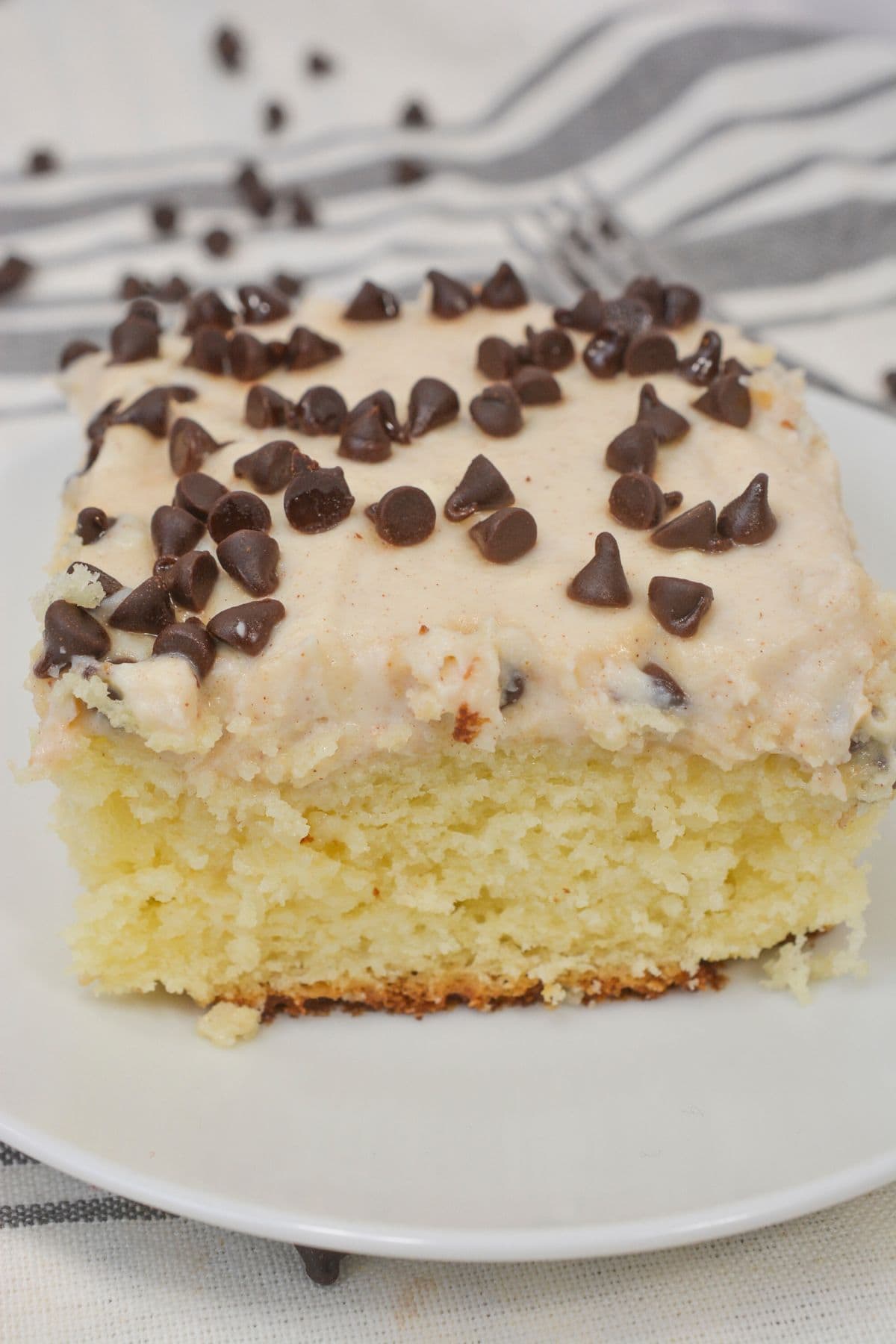 A moist slice of cannoli cake with chocolate chips on top.