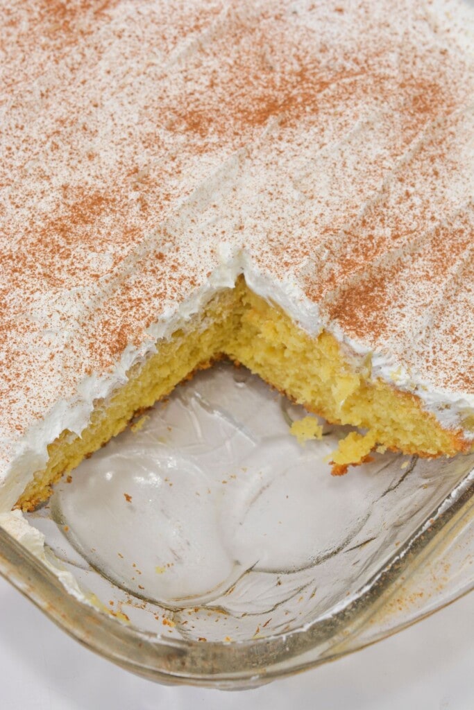 An eggnog poke cake with a slice taken out.