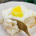 A fork in the cake with a lemon slice on top.