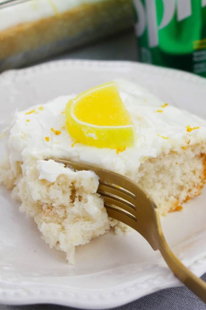 A fork in the cake with a lemon slice on top.
