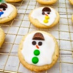 A melting snowman cookie with a top hat and green buttons.