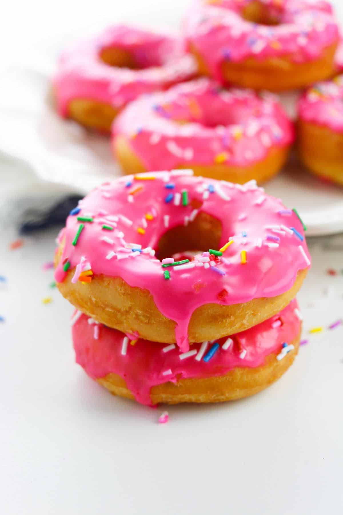 Stacks of pink sprinkle donuts.