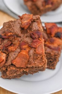 Two bacon brownies on a plate.