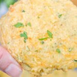 A hand holding the bisquick cheddar biscuit.