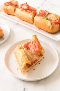 A slice of the garlic bread pizza on a white plate.