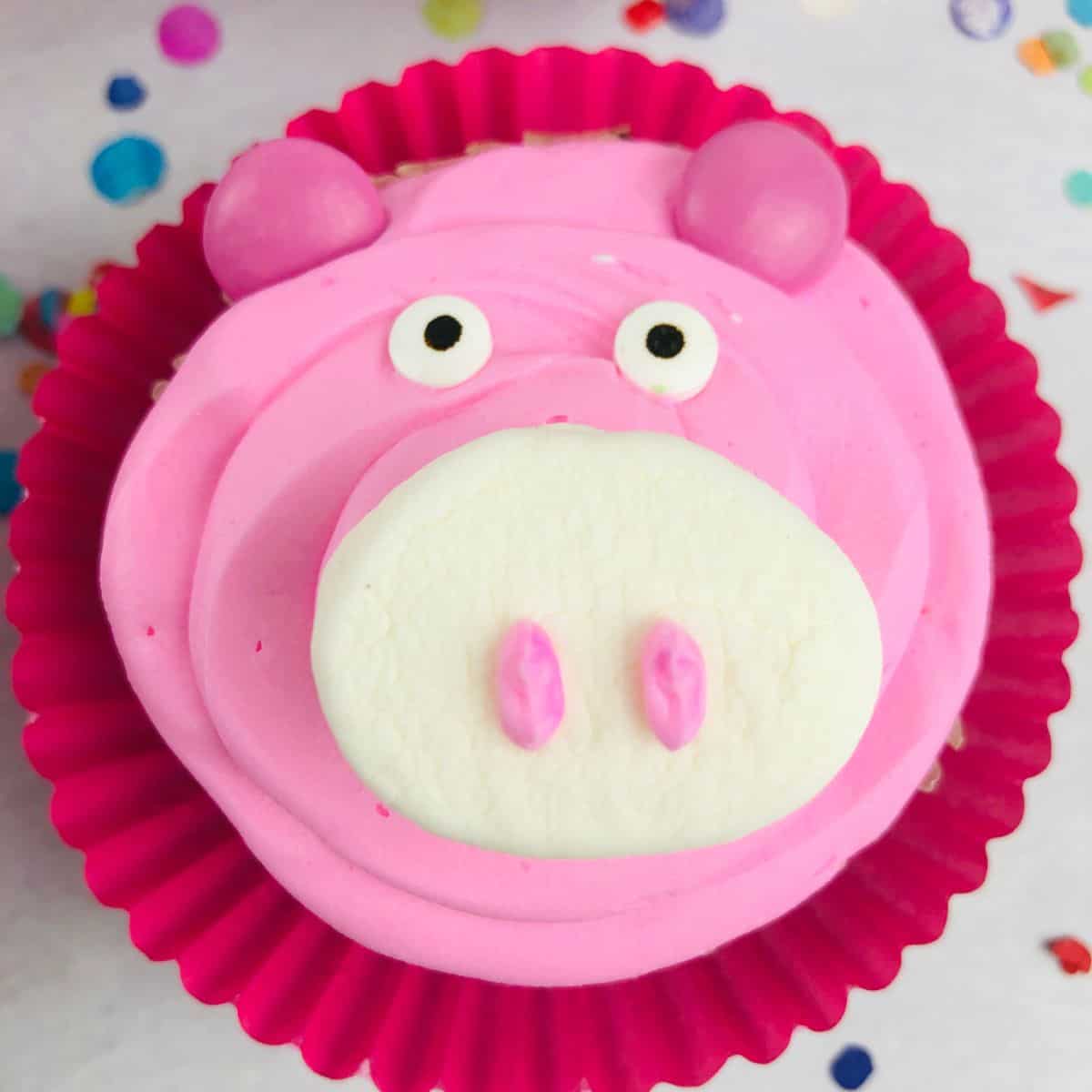 A happy pink pig cupcake ready for a party.
