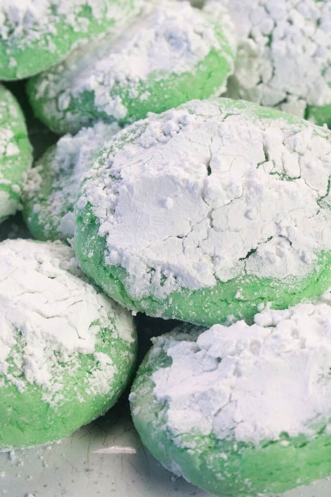 Powdered sugar covering some green cookies.