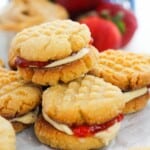 A stack of the desserts with strawberries in the background.